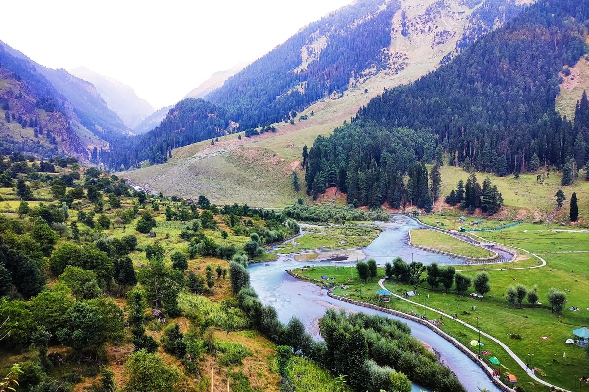 Panoramic view of Betaab Valley near Pahalgam surrounded by snow-covered Himalayan peaks and pine forests